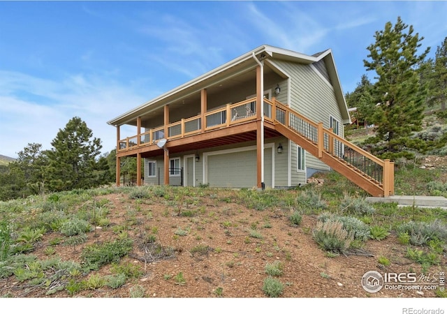 246 Nowata Dr, Red Feather Lakes, CO 80545 - back of property featuring an attached garage, a wooden deck, and stairway