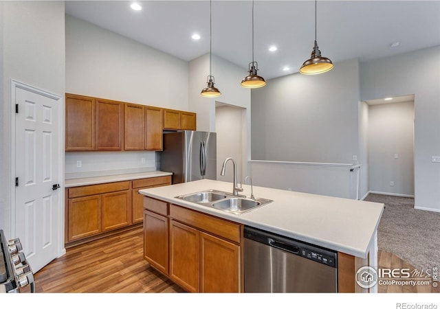 3997 Forest Lake Ct, Loveland, CO 80538 - kitchen with appliances with stainless steel finishes, a sink, brown cabinets, light countertops, and hanging light fixtures