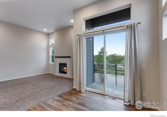 3997 Forest Lake Ct, Loveland, CO 80538 - unfurnished living room with wood finished floors, baseboards, a glass covered fireplace, and recessed lighting