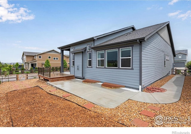 3997 Forest Lake Ct, Loveland, CO 80538 - view of front facade featuring a patio area, a shingled roof, and a wooden deck