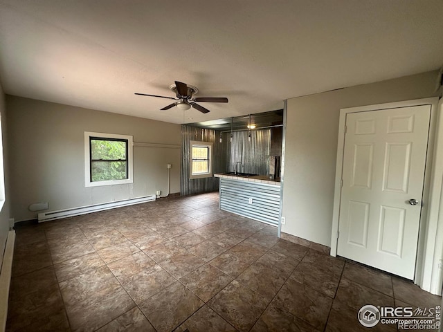 721 Phelps St, Sterling, CO 80751 - unfurnished living room with a baseboard heating unit, a ceiling fan, and baseboards