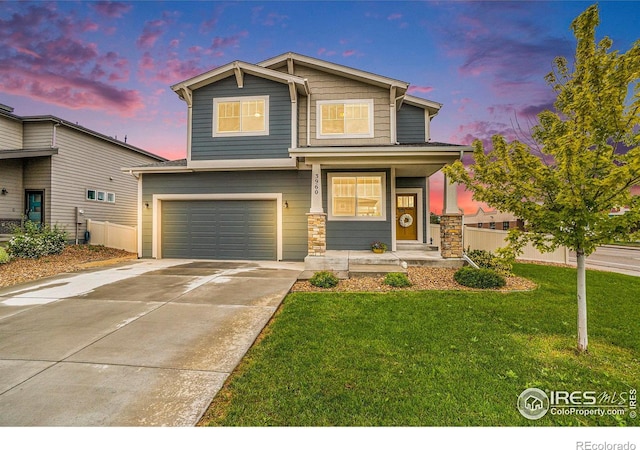 3960 Sweetgum St, Wellington, CO 80549 - view of front of property with a garage, concrete driveway, a porch, and stone siding