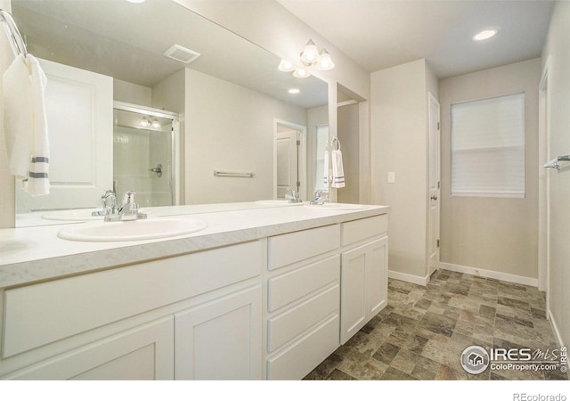 3960 Sweetgum St, Wellington, CO 80549 - full bathroom with double vanity, a stall shower, stone finish floors, baseboards, and recessed lighting