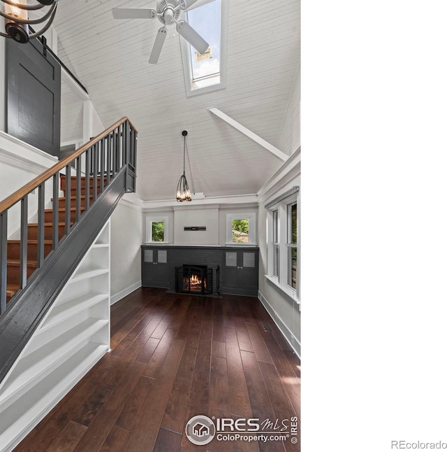 1010 Euclid Ave, Boulder, CO 80302 - unfurnished living room with high vaulted ceiling, stairs, ceiling fan, a lit fireplace, and hardwood / wood-style floors