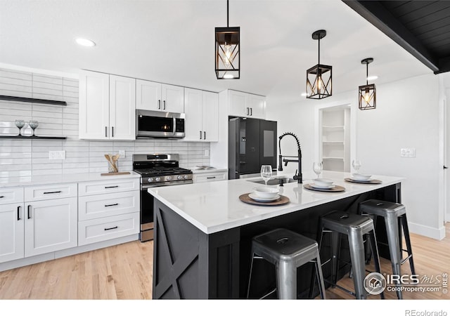 6766 Zenobia Loop, Westminster, CO 80030 - kitchen featuring appliances with stainless steel finishes, open shelves, white cabinets, light wood-style floors, and recessed lighting