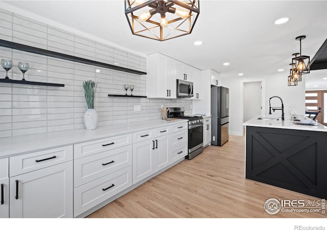 6766 Zenobia Loop, Westminster, CO 80030 - kitchen with appliances with stainless steel finishes, open shelves, a chandelier, white cabinets, and backsplash