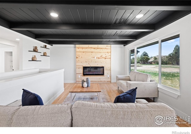 6766 Zenobia Loop, Westminster, CO 80030 - living area with a glass covered fireplace, wood finished floors, baseboards, and wood ceiling with exposed beams