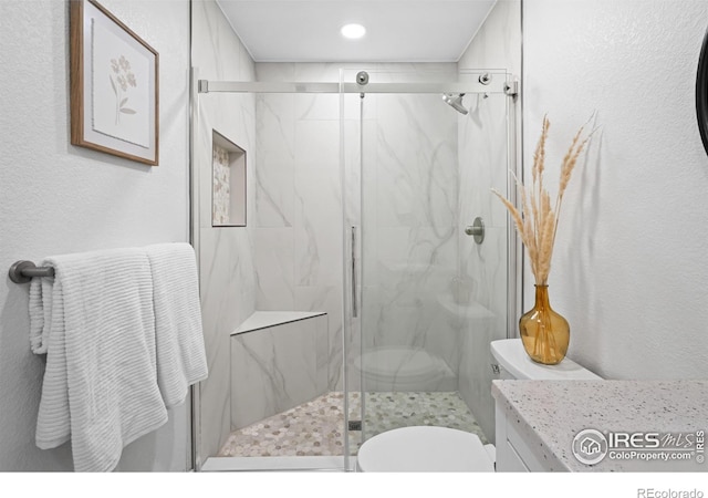 6766 Zenobia Loop, Westminster, CO 80030 - bathroom featuring toilet, a textured wall, a marble finish shower, vanity, and recessed lighting