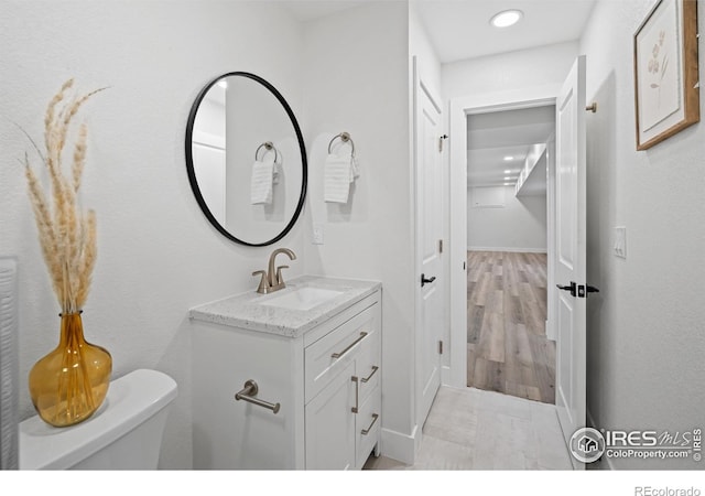 6766 Zenobia Loop, Westminster, CO 80030 - bathroom featuring vanity, toilet, recessed lighting, and baseboards