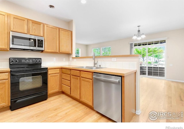 3180 Springfield Dr, Loveland, CO 80538 - kitchen featuring stainless steel appliances, a sink, a peninsula, light wood finished floors, and recessed lighting