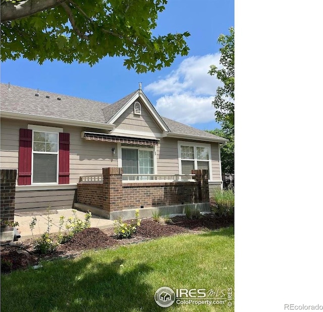 3180 Springfield Dr, Loveland, CO 80538 - view of front of house with brick siding, a front lawn, and a shingled roof