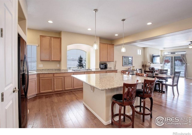 1060 Arrowhead Ct, Erie, CO 80516 - kitchen with light brown cabinets, light wood-type flooring, a center island, light stone countertops, and recessed lighting