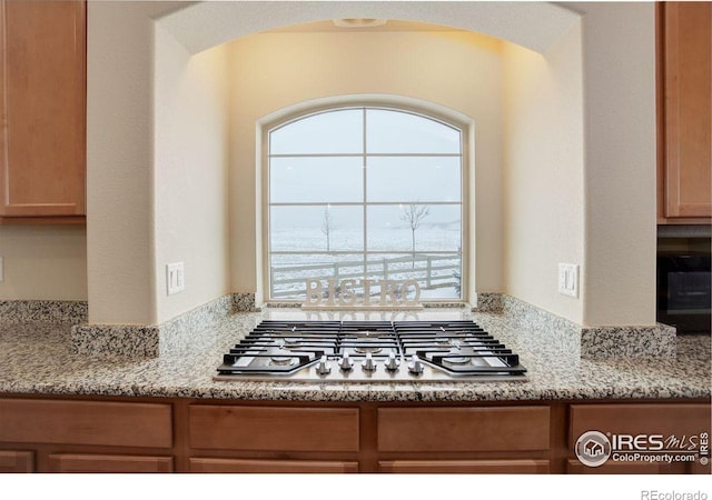 1060 Arrowhead Ct, Erie, CO 80516 - kitchen with stainless steel gas cooktop, light stone counters, and arched walkways