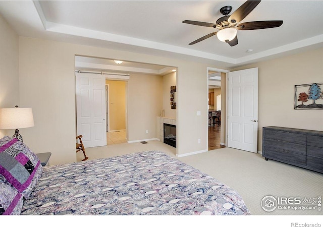 1060 Arrowhead Ct, Erie, CO 80516 - carpeted bedroom with a tray ceiling, a tile fireplace, and a ceiling fan