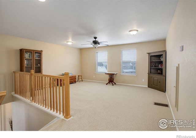 1060 Arrowhead Ct, Erie, CO 80516 - living area with ceiling fan, carpet flooring, baseboards, and an upstairs landing