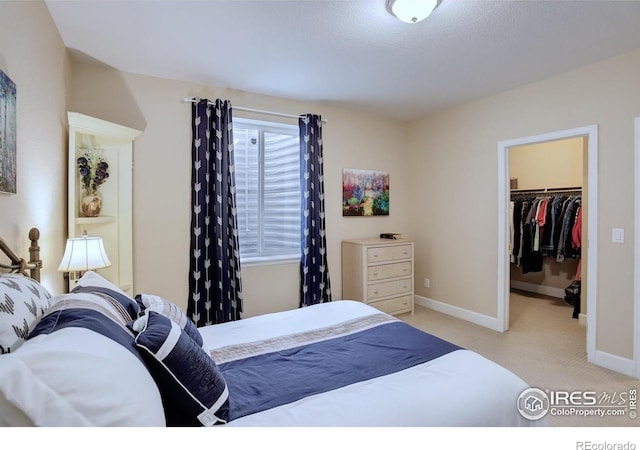 1060 Arrowhead Ct, Erie, CO 80516 - bedroom with a walk in closet, light colored carpet, baseboards, and a closet