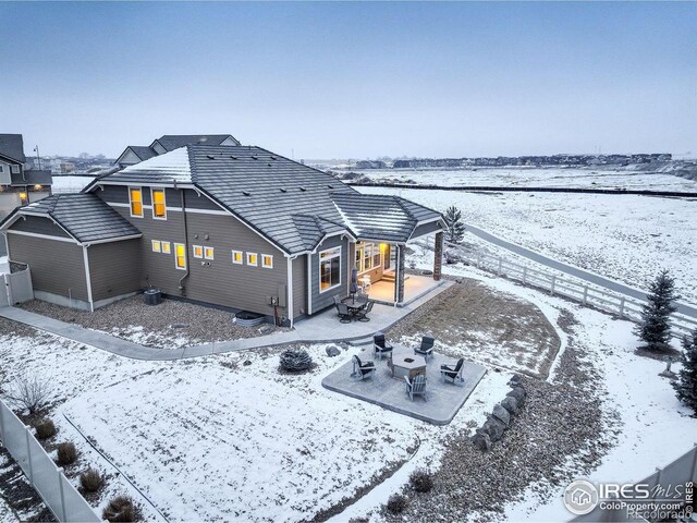 1060 Arrowhead Ct, Erie, CO 80516 - snow covered house featuring a patio and a fenced backyard