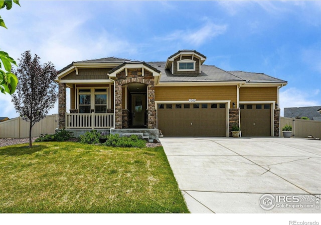 1060 Arrowhead Ct, Erie, CO 80516 - view of front of home featuring stone siding, a porch, a garage, and driveway