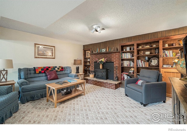 6009 W 28th St W, Greeley, CO 80634 - carpeted living area featuring a wood stove, wood walls, and a textured ceiling