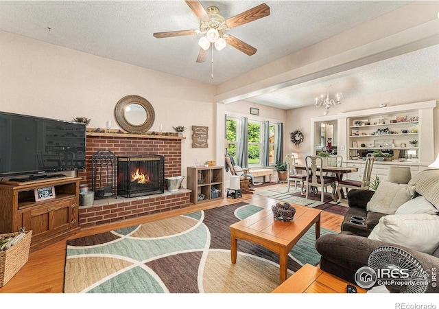 6009 W 28th St W, Greeley, CO 80634 - living room with wood finished floors, a fireplace, ceiling fan, a textured ceiling, and a chandelier