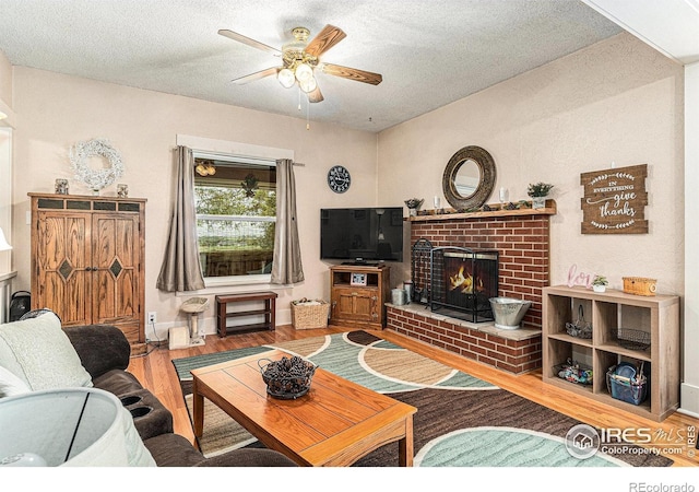 6009 W 28th St W, Greeley, CO 80634 - living room featuring a brick fireplace, wood finished floors, a textured ceiling, and ceiling fan