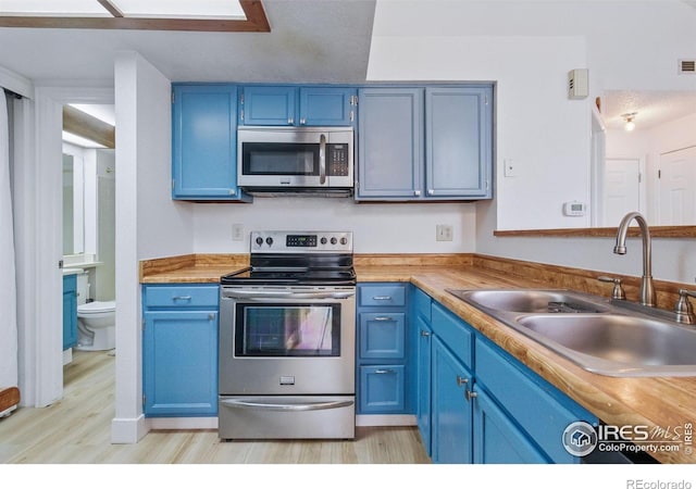 6076 Gunbarrel Ave Unit F, Boulder, CO 80301 - kitchen with appliances with stainless steel finishes, a sink, and blue cabinetry