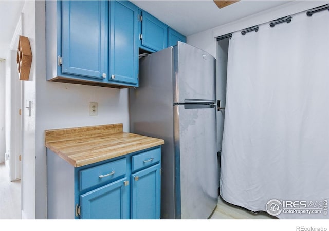 6076 Gunbarrel Ave Unit F, Boulder, CO 80301 - kitchen featuring blue cabinets and freestanding refrigerator