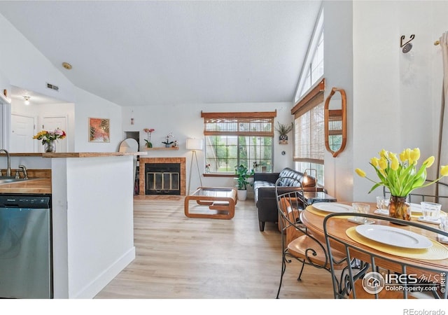 6076 Gunbarrel Ave Unit F, Boulder, CO 80301 - living room with vaulted ceiling, light wood-style flooring, a brick fireplace, and baseboards