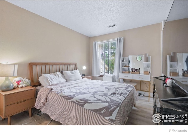 6076 Gunbarrel Ave Unit F, Boulder, CO 80301 - bedroom featuring light wood-type flooring and a textured ceiling