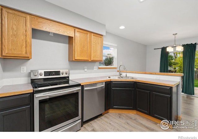 3816 Partridge Ct, Evans, CO 80620 - kitchen featuring appliances with stainless steel finishes, a sink, a peninsula, light countertops, and plenty of natural light