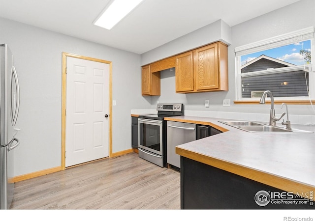 3816 Partridge Ct, Evans, CO 80620 - kitchen with appliances with stainless steel finishes, a sink, light wood-style flooring, and light countertops