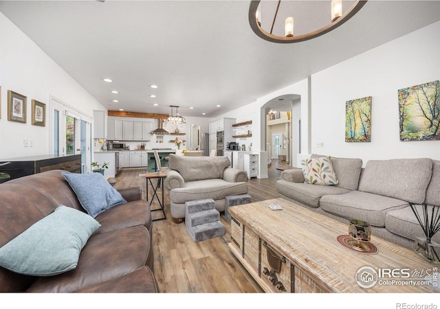 1892 Bell Dr, Erie, CO 80516 - living area with arched walkways, light wood-style flooring, and recessed lighting