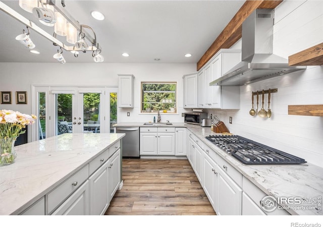 1892 Bell Dr, Erie, CO 80516 - kitchen with stainless steel appliances, a sink, wall chimney exhaust hood, recessed lighting, and white cabinetry