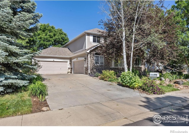 1892 Bell Dr, Erie, CO 80516 - obstructed view of property featuring an attached garage, concrete driveway, and stone siding