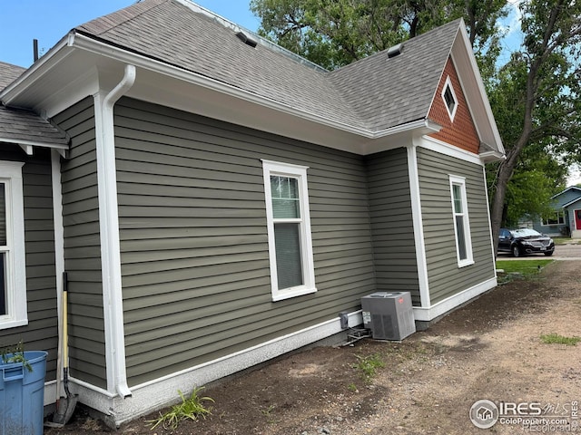 114 Park St, Sterling, CO 80751 - view of property exterior with roof with shingles and central AC unit