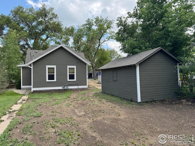 114 Park St, Sterling, CO 80751 - back of house featuring roof with shingles and an outbuilding