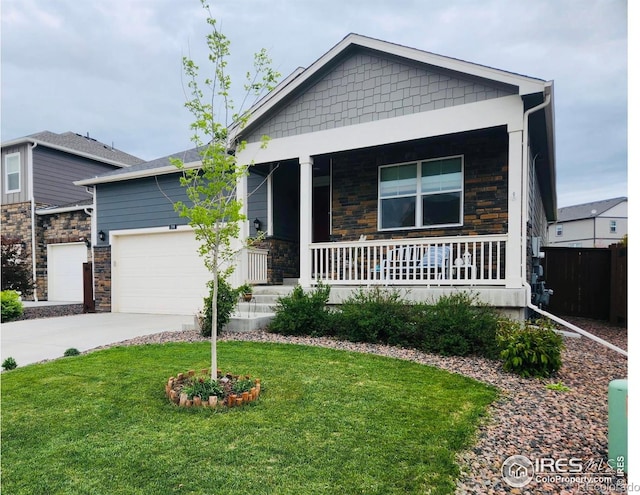 296 Swallow Rd, Johnstown, CO 80534 - view of front facade featuring stone siding, a porch, concrete driveway, and a front yard