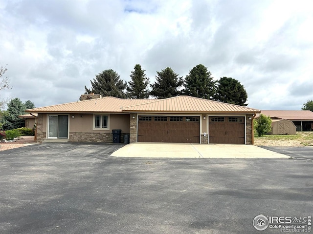 33180 Pikes Peak Dr, Greeley, CO 80631 - single story home with stone siding, an attached garage, driveway, and metal roof