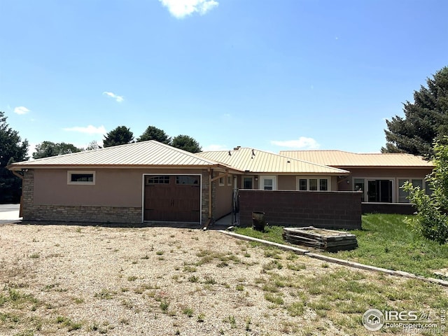 33180 Pikes Peak Dr, Greeley, CO 80631 - single story home featuring an attached garage, stucco siding, metal roof, stone siding, and driveway