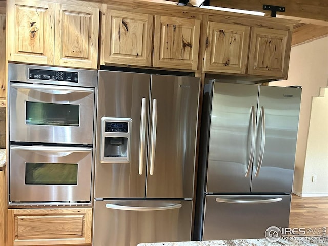 33180 Pikes Peak Dr, Greeley, CO 80631 - kitchen with appliances with stainless steel finishes, wood finished floors, and baseboards