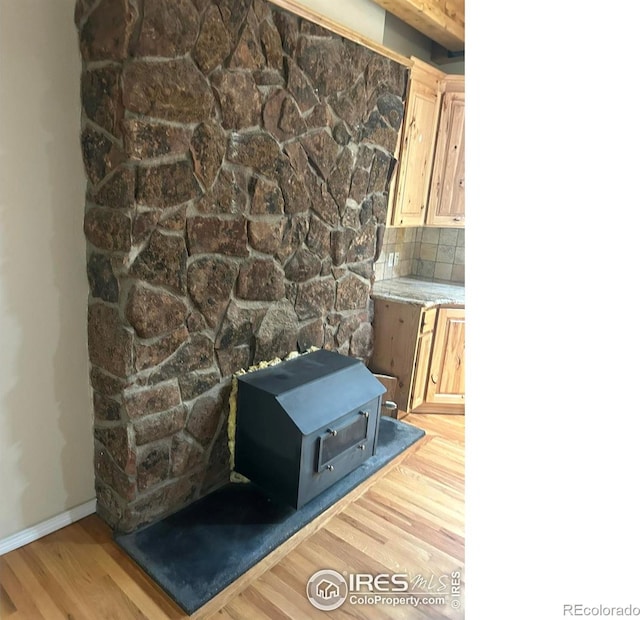 33180 Pikes Peak Dr, Greeley, CO 80631 - detailed view of a wood stove, wood finished floors, backsplash, and baseboards