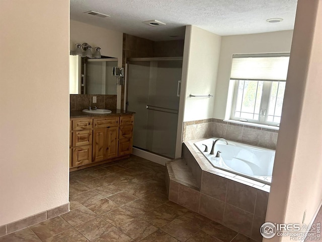 33180 Pikes Peak Dr, Greeley, CO 80631 - full bathroom with vanity, a textured ceiling, a stall shower, a garden tub, and stone finish floors