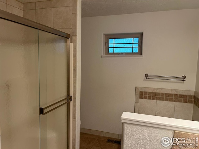 33180 Pikes Peak Dr, Greeley, CO 80631 - full bathroom with a shower stall, tile patterned flooring, toilet, and baseboards