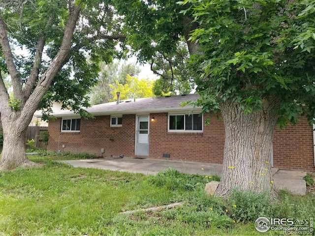 829 Hubbard Dr, Longmont, CO 80504 - back of property featuring brick siding, a patio, and crawl space