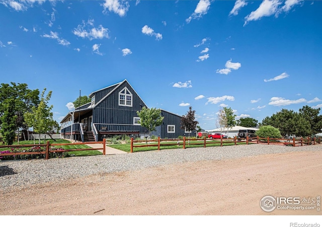 39445 Main St, Eaton, CO 80615 - view of front of property with board and batten siding, a fenced front yard, and covered porch