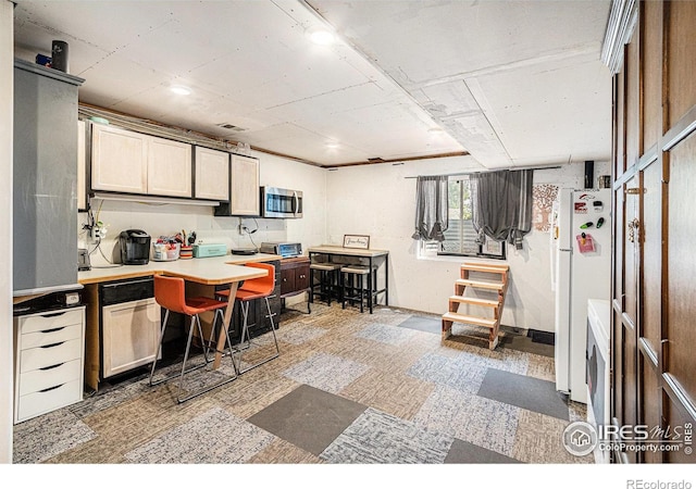 39445 Main St, Eaton, CO 80615 - kitchen featuring stainless steel microwave, light countertops, and freestanding refrigerator