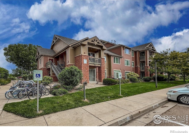 804 Summer Hawk Dr Unit 105, Longmont, CO 80504 - view of front of house with brick siding and a front lawn