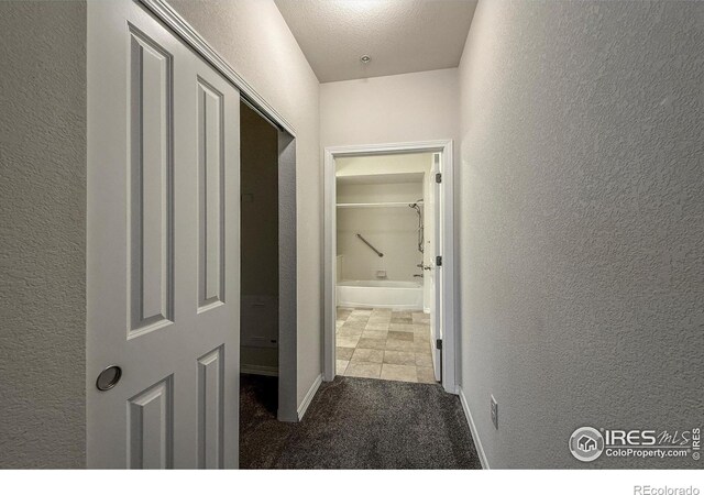 804 Summer Hawk Dr Unit 105, Longmont, CO 80504 - hallway with a textured wall, carpet floors, and baseboards