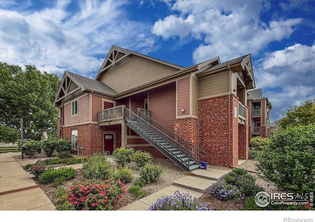 804 Summer Hawk Dr Unit 105, Longmont, CO 80504 - view of front facade featuring brick siding, stairway, and a porch