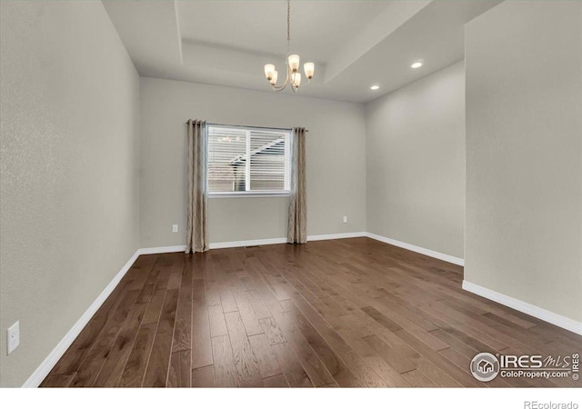 1368 Waterfall St, Timnath, CO 80547 - spare room featuring dark wood-style floors, a raised ceiling, a chandelier, and recessed lighting